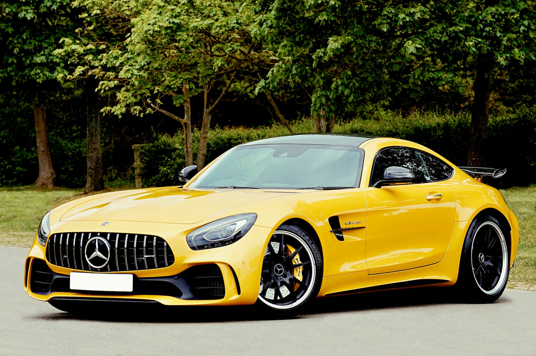 yellow mercedes benz beside trees