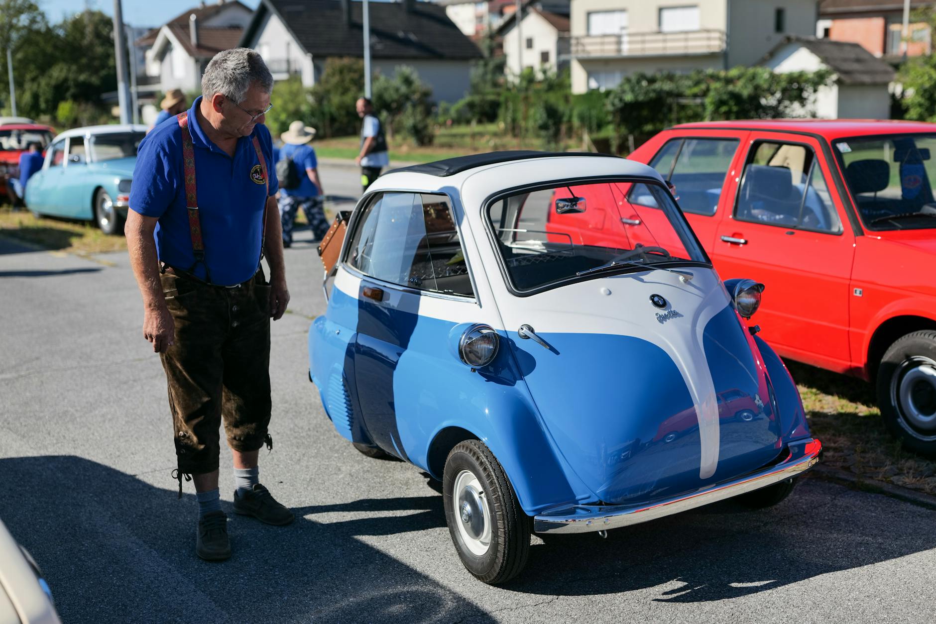 man looking at a vintage microcar