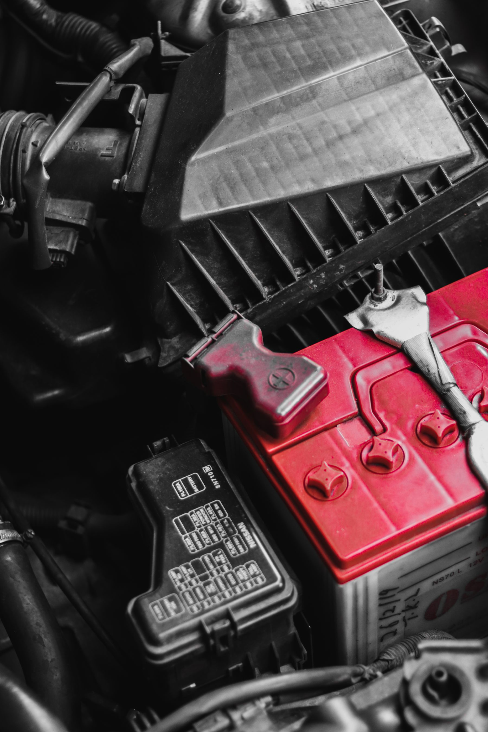Close-up of a car battery and terminals in an engine bay