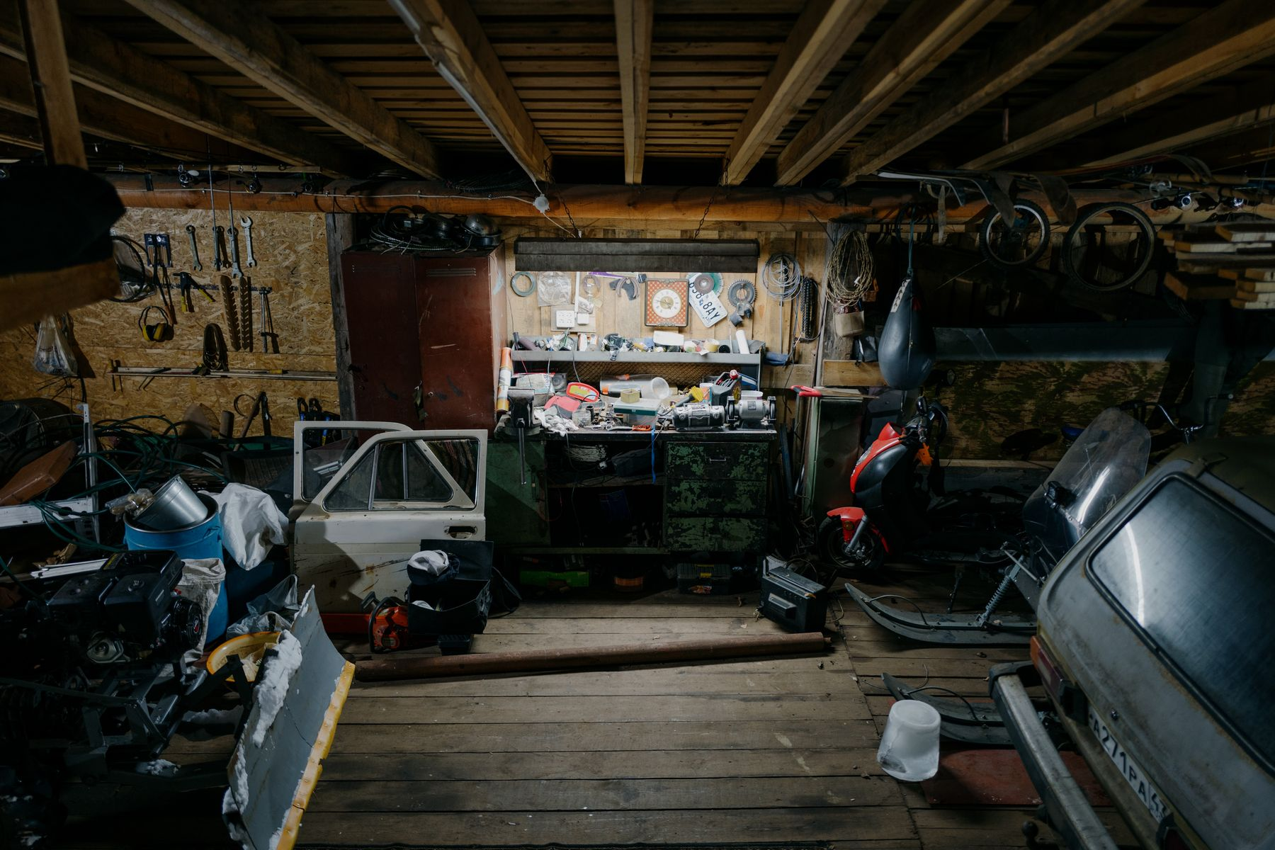 A home garage workshop with tools and a project car apart for restoration