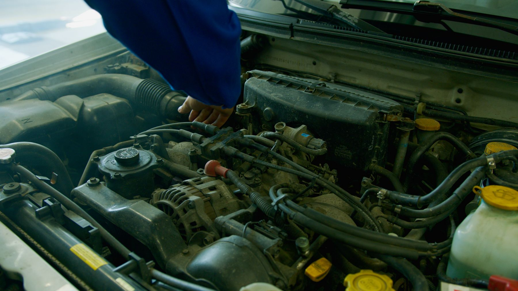 A mechanic working on a car engine in a garage