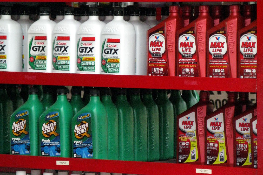 Store shelf with Castrol GTX motor oil bottles next to red Valvoline MaxLife high mileage bottles