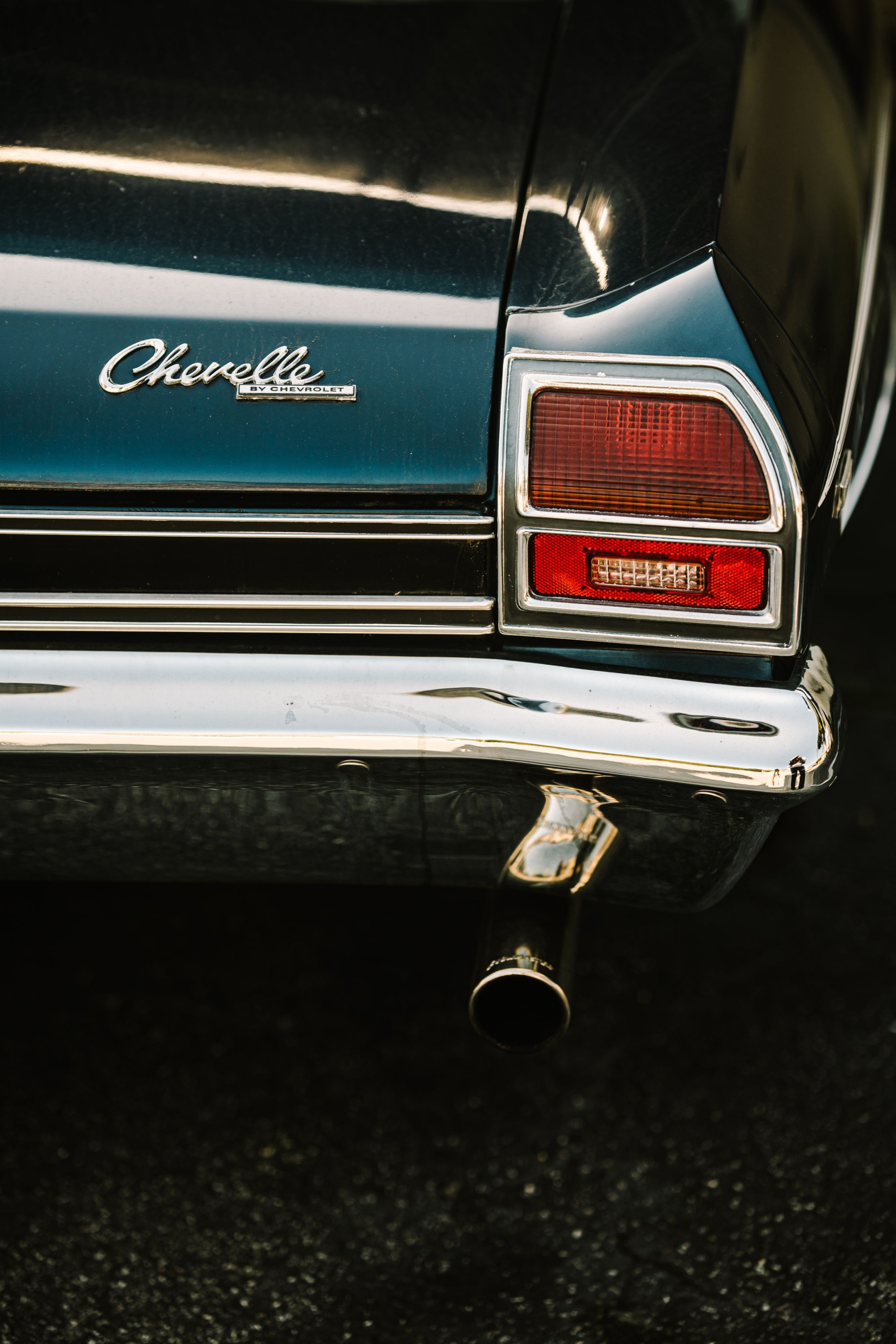 Rear quarter of a classic Chevrolet Chevelle with chrome Chevelle script, tail light, and bumper