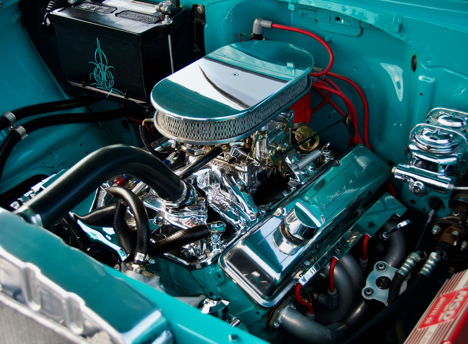 Restored classic V8 engine bay with chrome air cleaner and valve covers in a vintage car